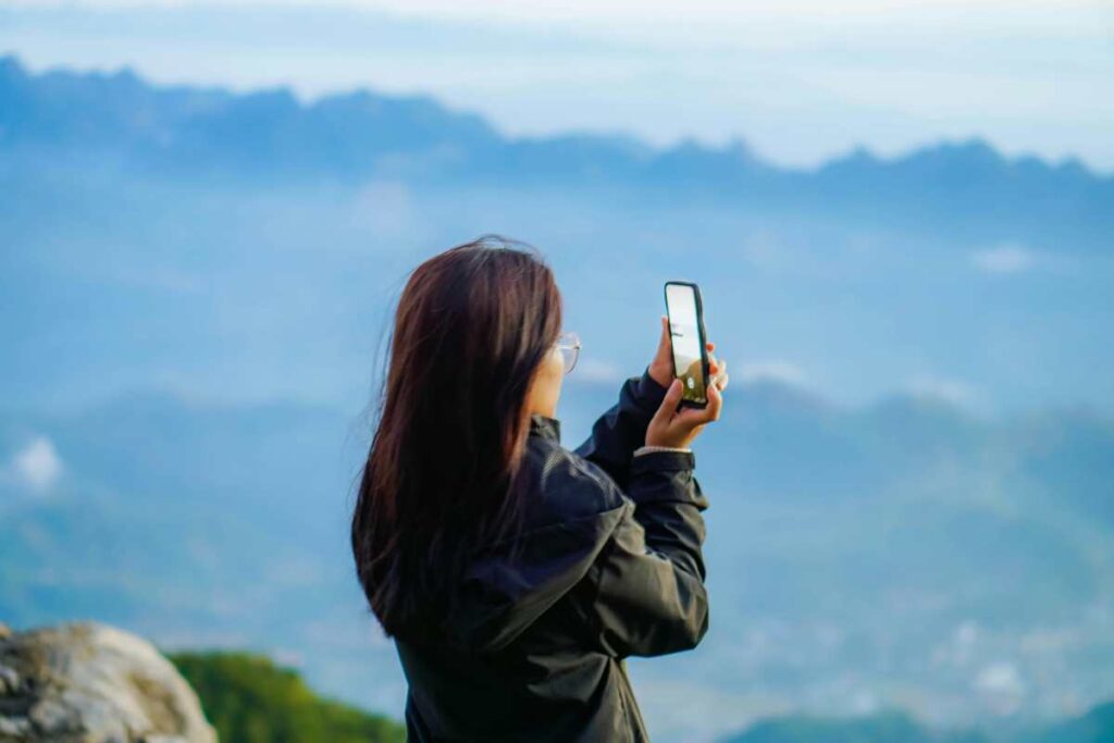 Huawei - femeie satena aflata la muntefacand poza la peisaj
