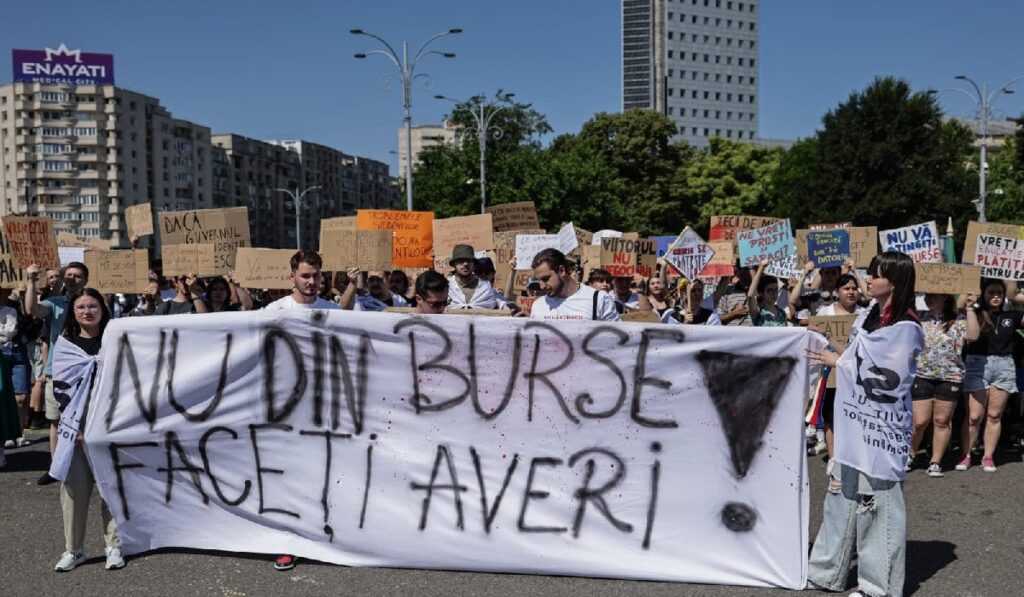 Mai mulți tineri țin pancarte în mâini în timpul unui protest al studenților din Bucuresti, 26 iunie 2025