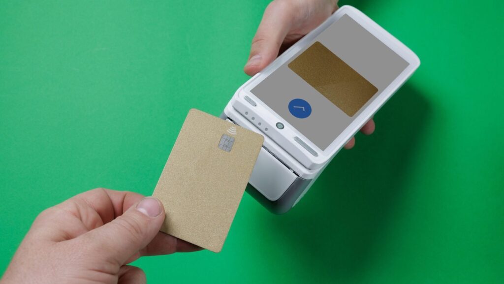 Imagine cu un bărbat care plătește contactless cu un card auriu