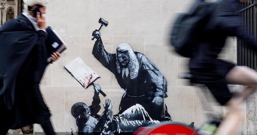Banksy, cenzurat pentru o nouă pictură murală. Artistul a desenat un judecător care bate un protestatar la Londra