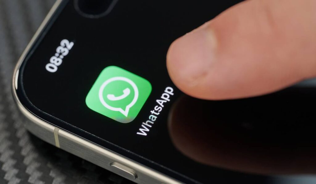 O persoană care apasă cu degetul pe ecranul telefonului și încearcă să intre pe WhatsApp