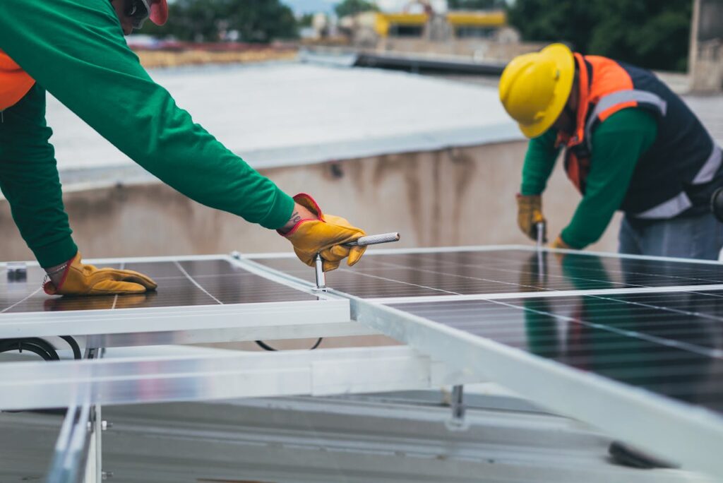 Muncitori care asambleaza panouri fotovoltaice