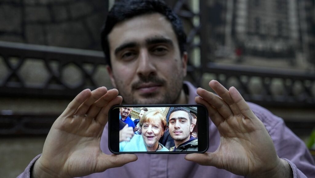 Anas Modamani, 27 de ani, refugiat sirian în Germania, arată faimoasa sa selfie cu cancelarul german Angela Merkel, pe care a făcut-o după sosirea sa în țară, într-un restaurant sirian din Berlin, marți, 10 decembrie 2024.
