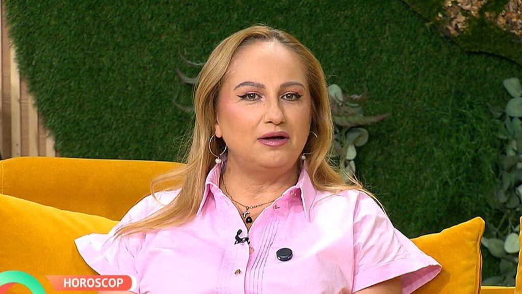 Astrologul Cristina Demetrescu, îmbrăcată cu o cămașă roz, stă pe o canapea portocalie, în studioul unei emisiuni TV, 22 septembrie 2025