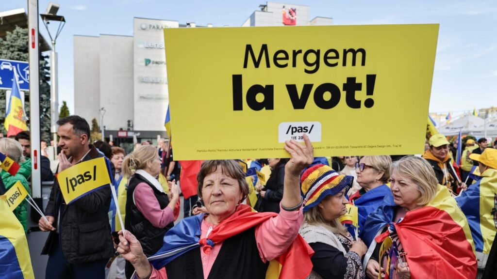 Protest pro PAS în Republica Moldova (1). O femeie in varsta tine in mana o pancarta galbena pe care se poate citi: Mergem la vot