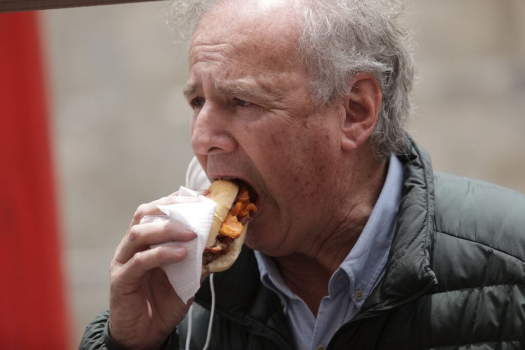 Alfredo Barnechea, membru al Partidului Acțiune Populară din Peru, mușcă dintr-o pâine cu șorici de porc, octombrie 2020