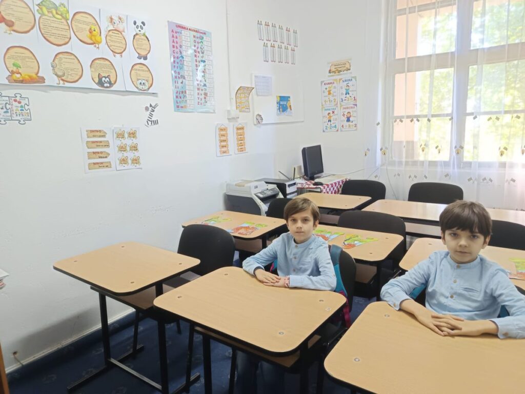 Elevi în bănci într-o clasă goală