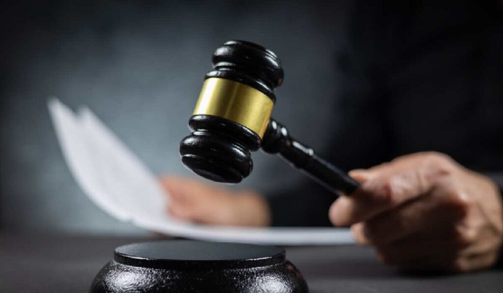 Judecător cu un document în mână pronunță sentința într-o instanță de judecată.
