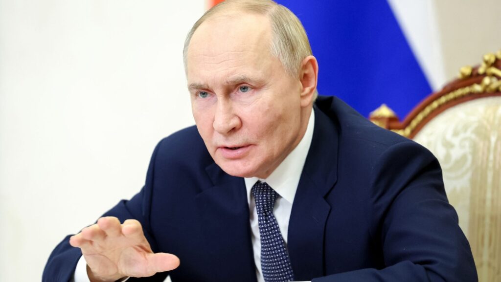 Vladimir Putin explică ceva gesticulând cu mâna, într-o manieră care atrage atenția că ceea ce spune e ceva serios