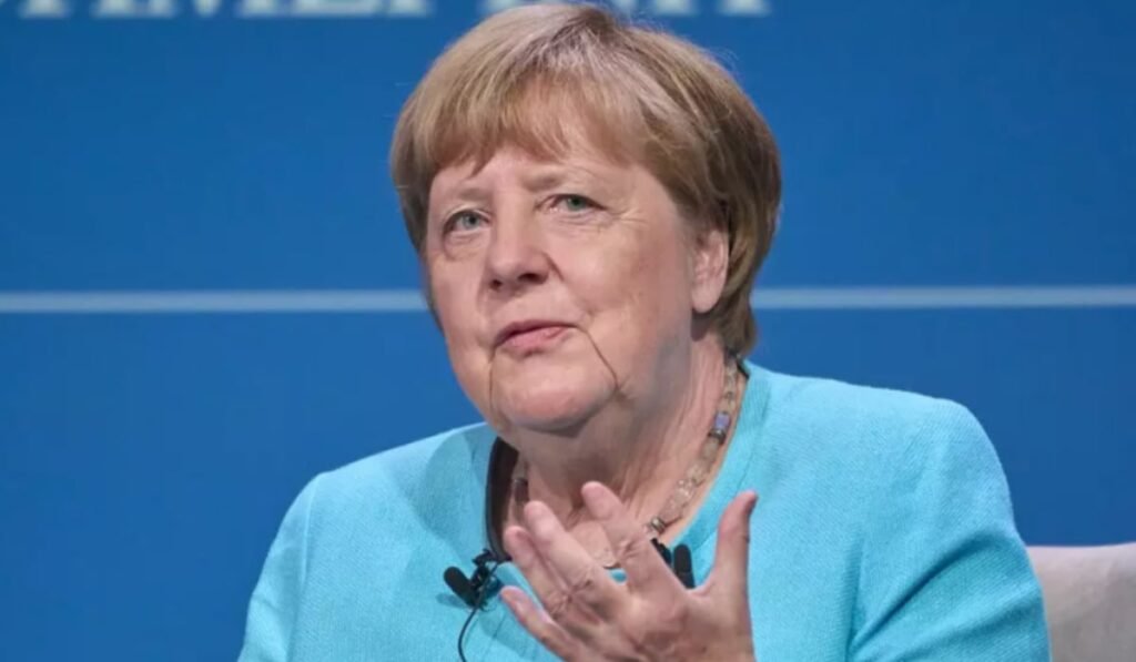 Angela Merkel într-un costum albastru în timp ce vorbește
