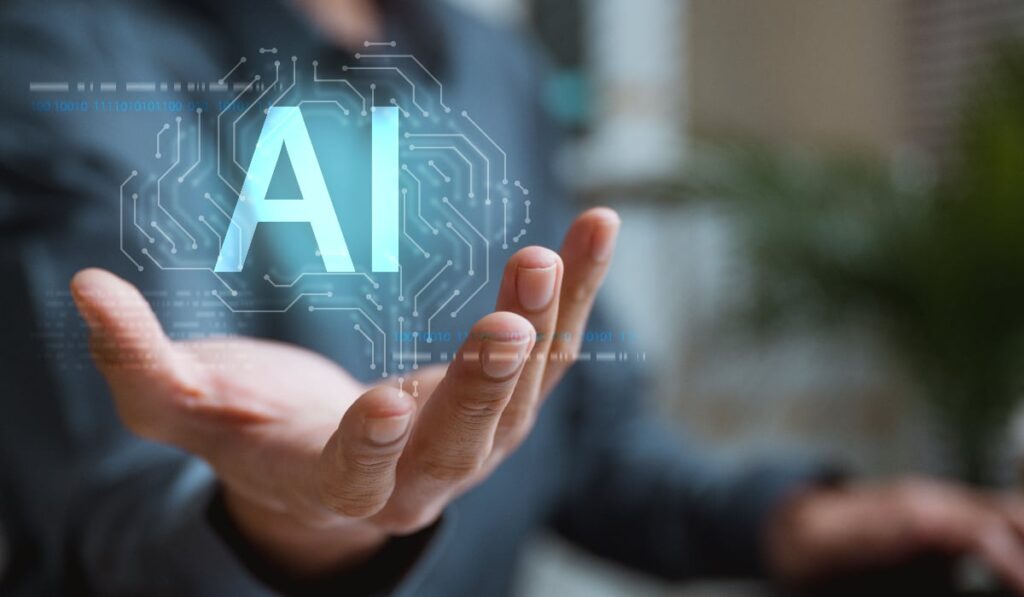 Mână care susține o proiecție digitală a textului "AI" (Inteligență Artificială)