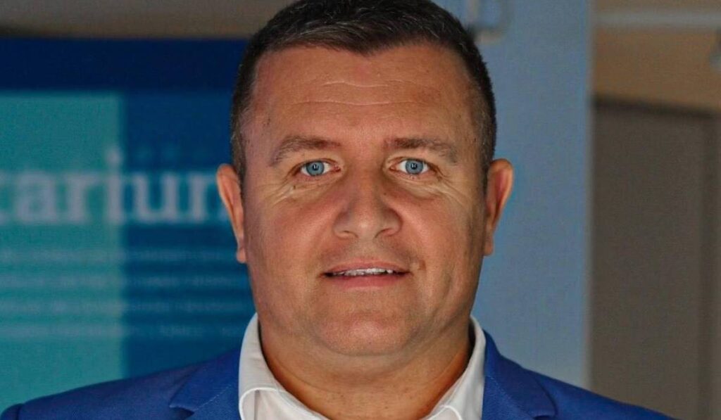 Primarul Ciprian Tamaș din județul Vaslui, într-un portret, are o cămașă albă și un sacou albastru și privește fix la camera de fotografiat