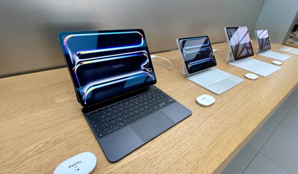 Mai multe iPad-uri Pro, așezate pe o masă de lemn dintr-un magazin Apple.
