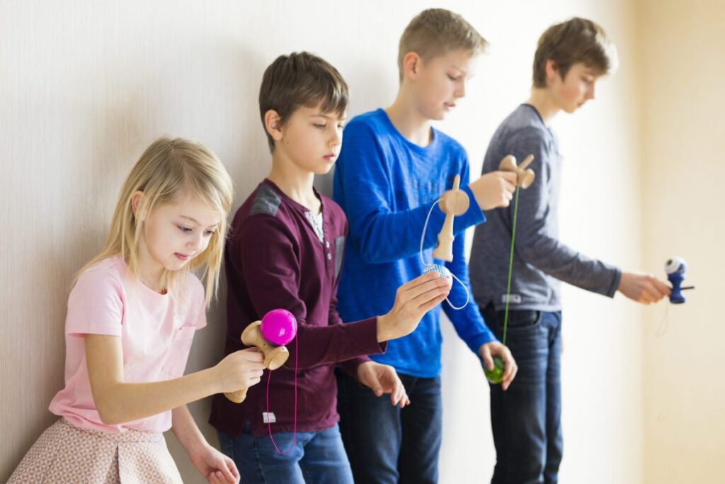 copii care se joaca cu kendama