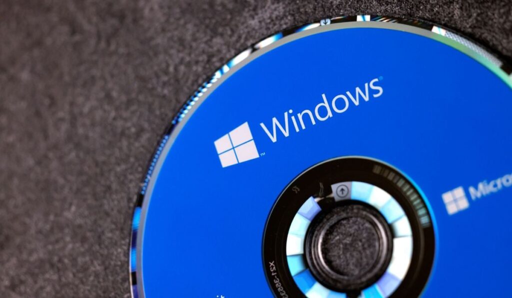 Un CD albastru de instalare cu Microsoft Windows 10, așezat pe o masă.