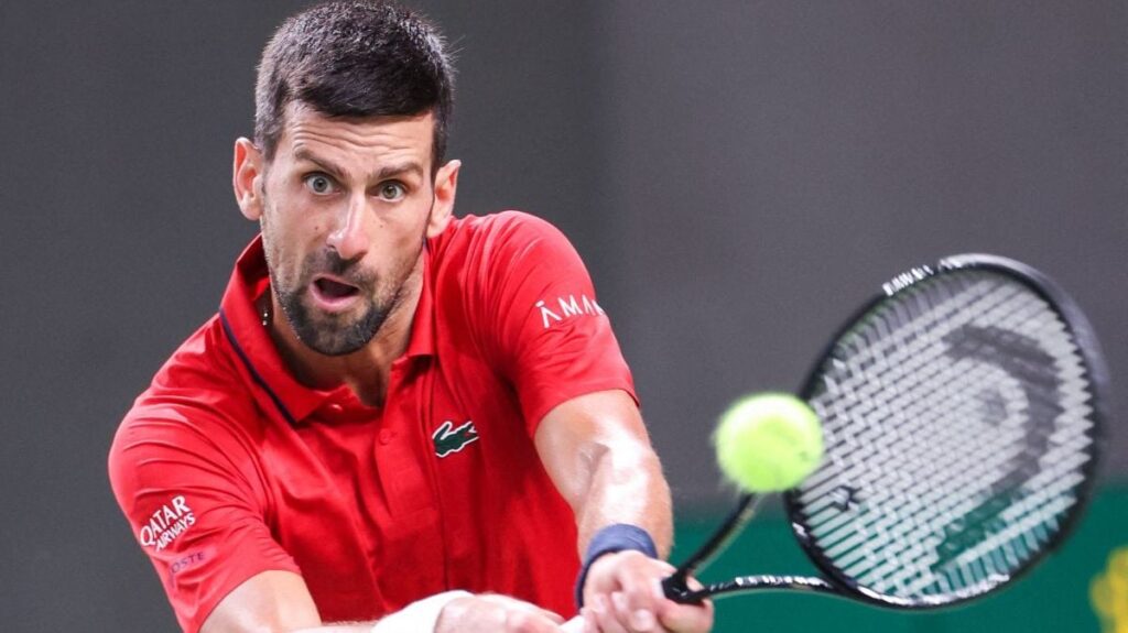Novak Djokovici, îmbrăcat într-un tricou roșu, returnează o minge în timpul unie meci din cadrul turneului de la Shanghai, China, octombrie 2025