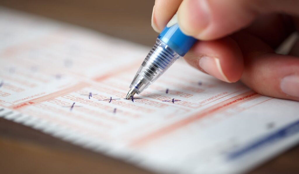 Un bărbat din Germania a ascuns de propria soție câștigul la loto: care este motivul O persoană care bifează numere pe un bilet loto