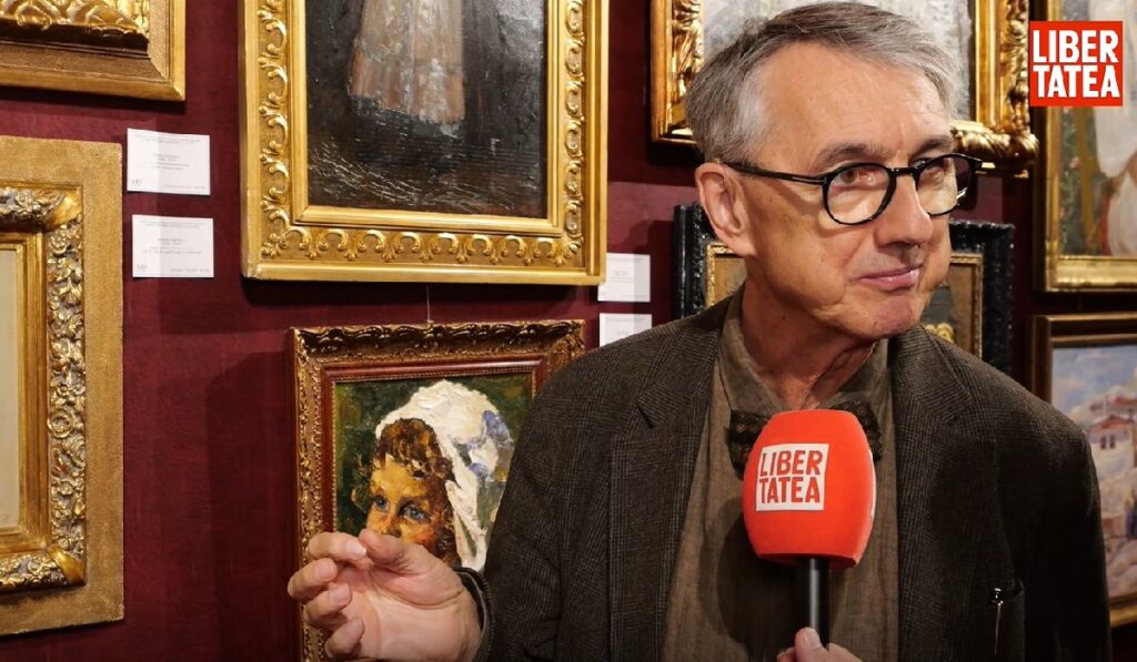 Un bărbat cu ochelari, Horia-Roman Patapievici, vorbește la un icrofon pe care scrie Libertatea, în spatele lui fiind mai multe tablouri